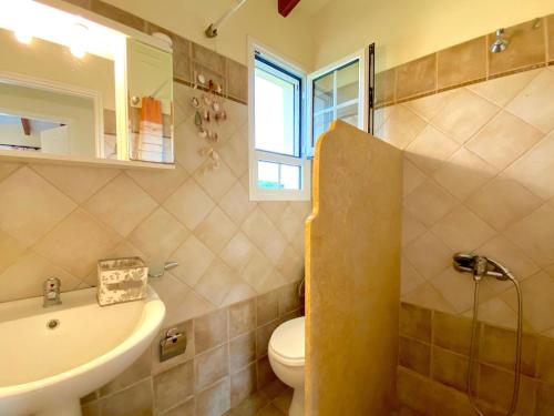 a bathroom with a sink and a toilet and a sink at Asteraki Poolside Apartment in Acharavi