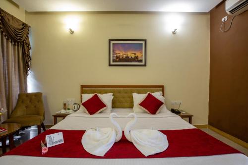 a hotel room with a bed with two wedding towels at KSTDC Hotel Mayura Hoysala, Mysore in Mysore