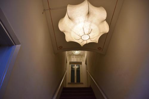 a chandelier in a hallway with a stairway at Coppo 1829 in Portacomaro