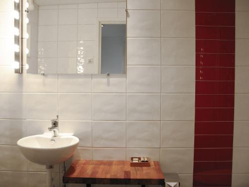 a white bathroom with a sink and a mirror at Nösundsgården Hotell & Vandrarhem in Nösund