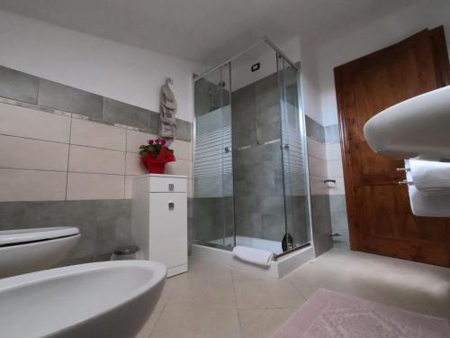 a bathroom with a shower and a tub and a toilet at B&B SA SPIGA in Marrùbiu