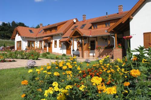 a house with a garden of flowers in the yard at Faluszéli Vendégház - Boncz Porta in Nagyrákos