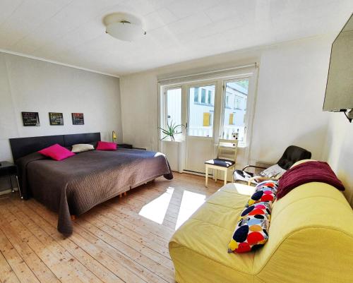 ein Schlafzimmer mit zwei Betten und einem Sofa darin in der Unterkunft Nösundsgården Hotell & Vandrarhem in Nösund