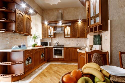 uma cozinha com armários de madeira e uma mesa com frutas em Large EuApartments em Hrodna