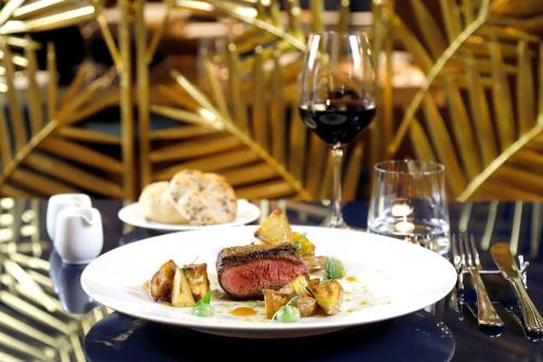 a plate of food on a table with a glass of wine at Bianca Maria Palace Hotel in Milan