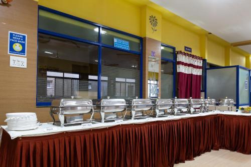 a long table with a row of plates and dishes at KSTDC Hotel Mayura Hoysala, Mysore in Mysore