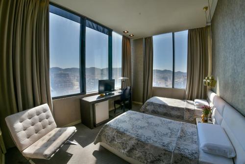 a hotel room with two beds and a desk at La Bohème Hotel in Tirana