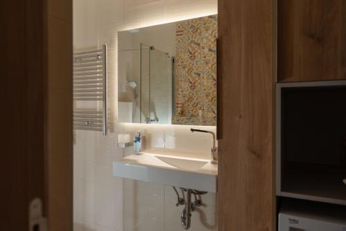 a bathroom with a sink and a mirror at Republic Square Apartment - with garage in Novi Sad