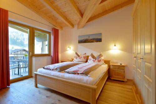 1 dormitorio con cama y ventana grande en Appartement Erlenau en Ellmau
