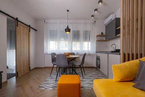 Republic Square Apartment - with garage في نوفي ساد: مطبخ وغرفة معيشة مع طاولة وكراسي
