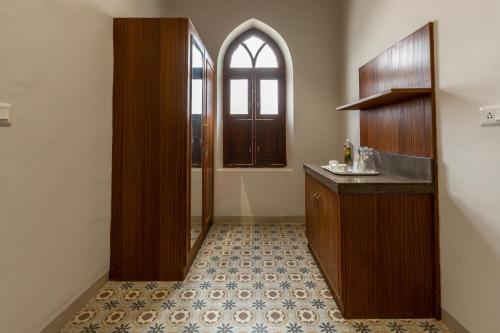 a bathroom with a sink and a mirror and a window at KSTDC Hotel Mayura Hoysala, Mysore in Mysore