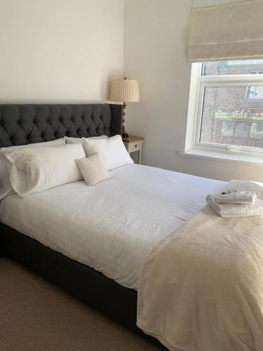 a bedroom with a large white bed with a window at Durham Serviced Properties - The Sanctuary in Durham