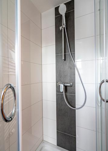 una doccia con soffione in un bagno di Hotel Restaurant Schwert a Kehl am Rhein