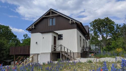 een wit huis met een bruin dak bij Kvarnvillan Lummelundsbruk in Visby