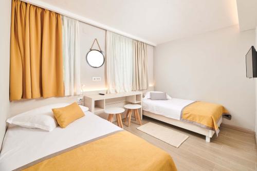 um quarto de hotel com duas camas e uma secretária em Villas Bellevue Plava Laguna em Poreč