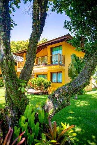 a yellow house with a balcony on a yard at BELLA VISTA Village in Arraial d'Ajuda