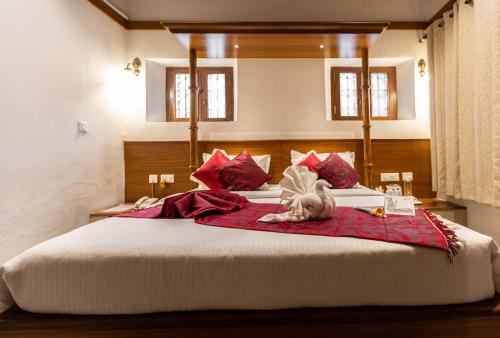 a cat laying on top of a large bed at KSTDC Hotel Mayura Hoysala, Mysore in Mysore