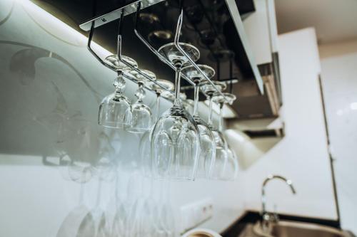 a row of wine glasses hanging from a kitchen counter at Vanagupės Terasa in Palanga