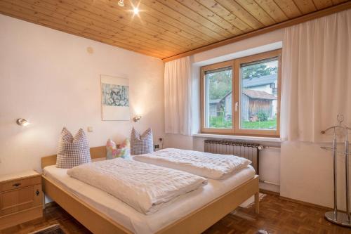 1 dormitorio con cama y ventana en Försterhaus Wohnung Obergeschoss, en Egg