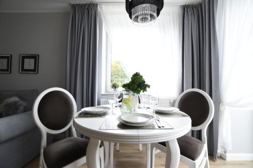 a white dining room table with chairs and a window at Apartamenty Pod Gwiazdami in Ustroń