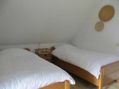 2 Betten in einem Zimmer mit weißer Bettwäsche in der Unterkunft Vakantiehuis Het Wapen van Heeckeren in Hummelo