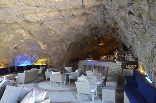 a restaurant in a cave with a stone wall at Grand Hotel Excelsior in Amalfi