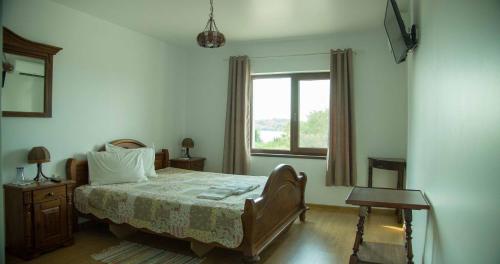 Schlafzimmer mit einem Bett und einem Fenster in der Unterkunft Къща за гости Лодката in Tutrakan