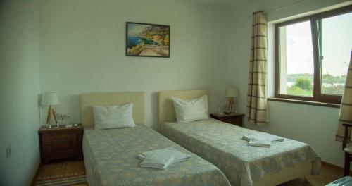 una camera d'albergo con due letti e una finestra di Къща за гости Лодката a Tutrakan