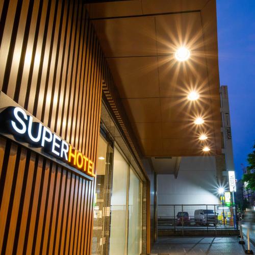 a store with a sign on the side of a building at Super Hotel Sendai Hirose Dori in Sendai