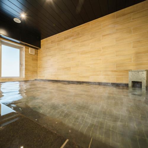 an empty room with a wood wall at Super Hotel Sendai Hirose Dori in Sendai