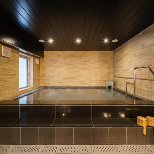 a large bath tub in a room with wooden walls at Super Hotel Sendai Hirose Dori in Sendai
