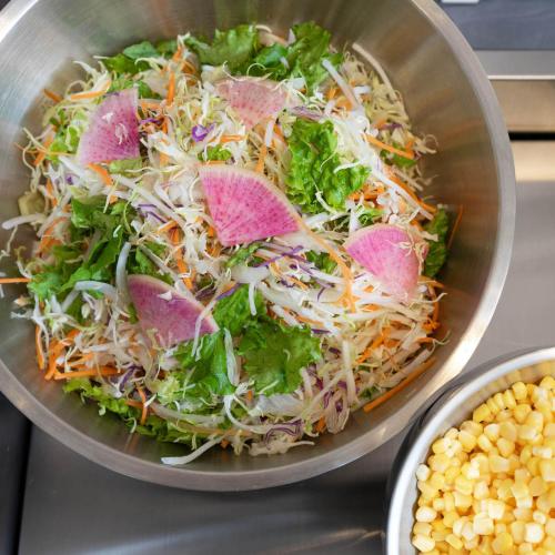 a salad in a bowl on a counter with corn at Super Hotel Sendai Hirose Dori in Sendai