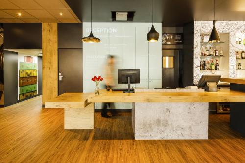 a kitchen with a wood floor and wooden cabinets at ibis Versailles Château in Versailles