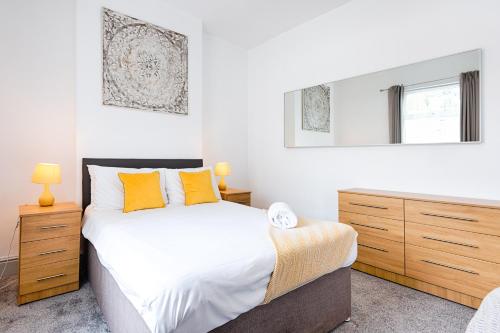 a bedroom with a large bed with orange pillows at Work Stay - 3BR - Near Stadium - Smart TVs in Swansea