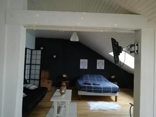 1 dormitorio con cama y pared negra en Le Petit Loft Vosgien, en Cornimont