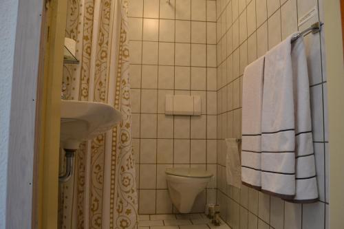 a bathroom with a sink and a toilet and towels at Motel Sydvest in Skærbæk
