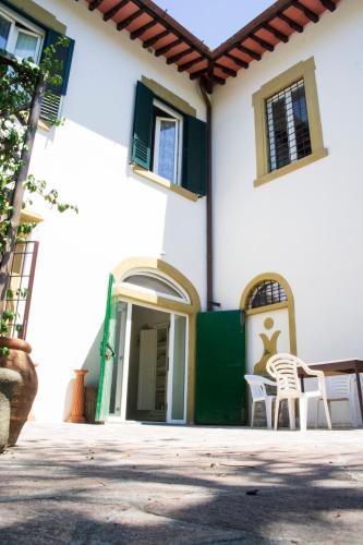 a white building with two chairs and a table at L'OZioRinco Apartments in Florence