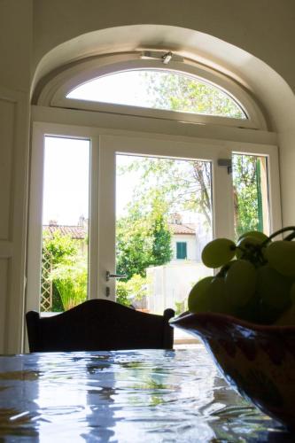 a table with a bowl of fruit on it in front of a window at L'OZioRinco Apartments in Florence