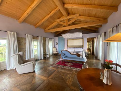 sala de estar con techos de madera, mesa y sillas en Tenuta Bricchi, en Sinio