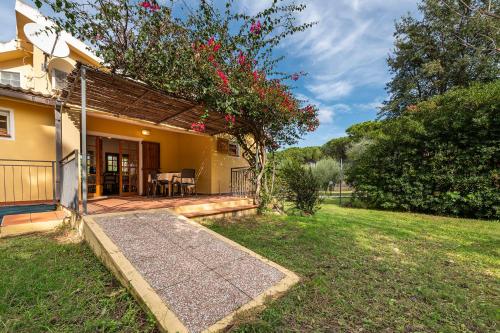 a house with a porch and a yard with a lawn sidx sidx sidx at Casa Vacanze Airone in Muravera