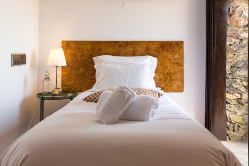 a large white bed with two pillows on it at Estalagem de Monsaraz in Monsaraz