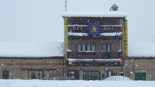 a building in the snow with a flag on it at Hotel Virginia R.H. in Vinuesa