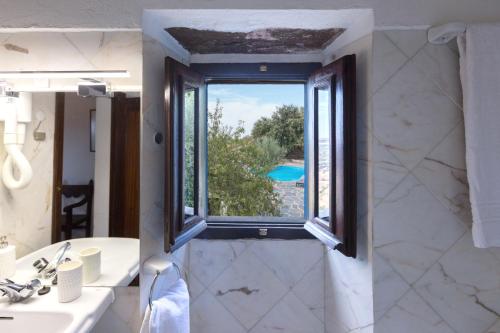 a bathroom with a sink and a window at Estalagem de Monsaraz in Monsaraz