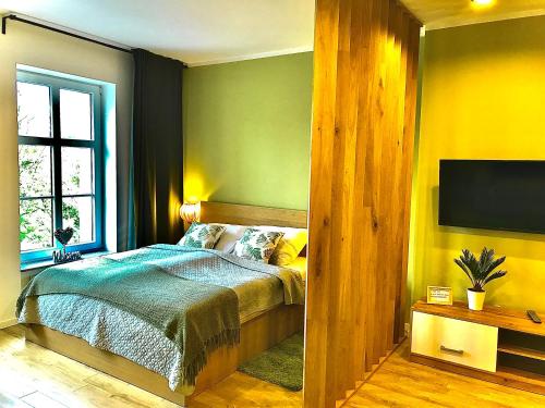 En eller flere senge i et værelse på Apartament „Green Wall”