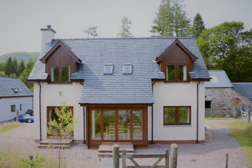 a white house with a gray roof at Shepherds Rest in Fort William