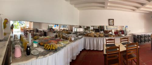 una línea de buffet con comida en un restaurante en Hotel Porto do Eixo Ubatuba en Ubatuba