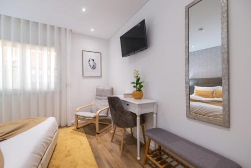 a bedroom with a bed and a desk and a mirror at 9 Quartos Alojamento in Avelar