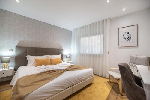 a bedroom with a large bed and a desk at 9 Quartos Alojamento in Avelar