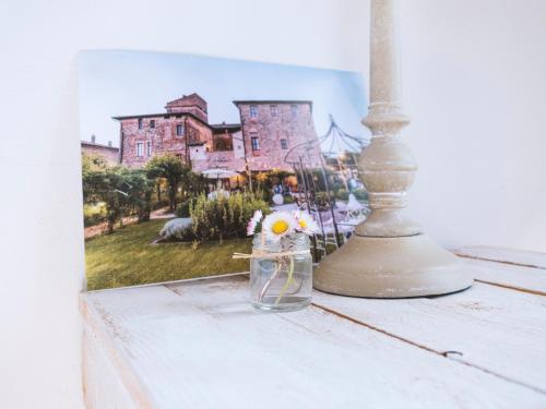 a glass jar with a flower in it next to a picture at Abbazia Sette Frati Agriturismo Fratres in Pietrafitta