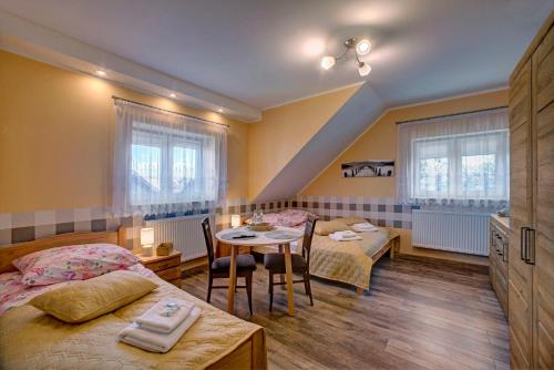 a bedroom with two beds and a table with chairs at Sanocka Willa in Sanok